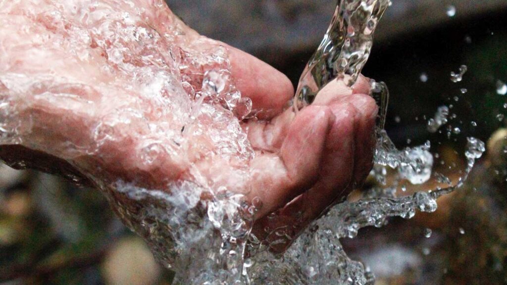 Agua fresca cayendo sobre una mano